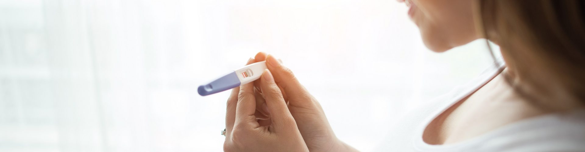 Young woman hand holding pregnancy test