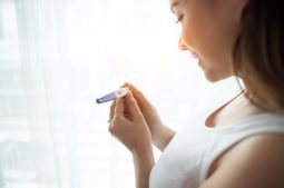 Young woman hand holding pregnancy test