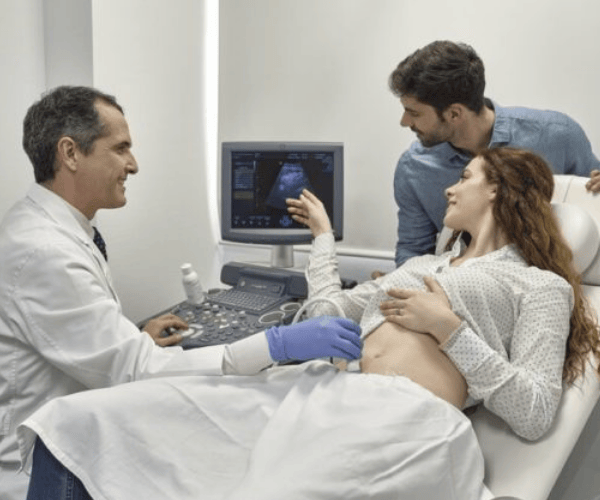 A woman getting a scan with a doctor and partner.